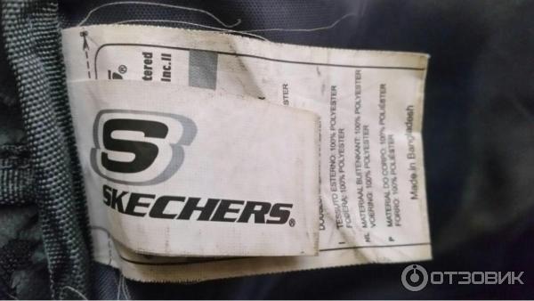 Бумажка на черном рюкзаке Skechers c коричневым смайликом